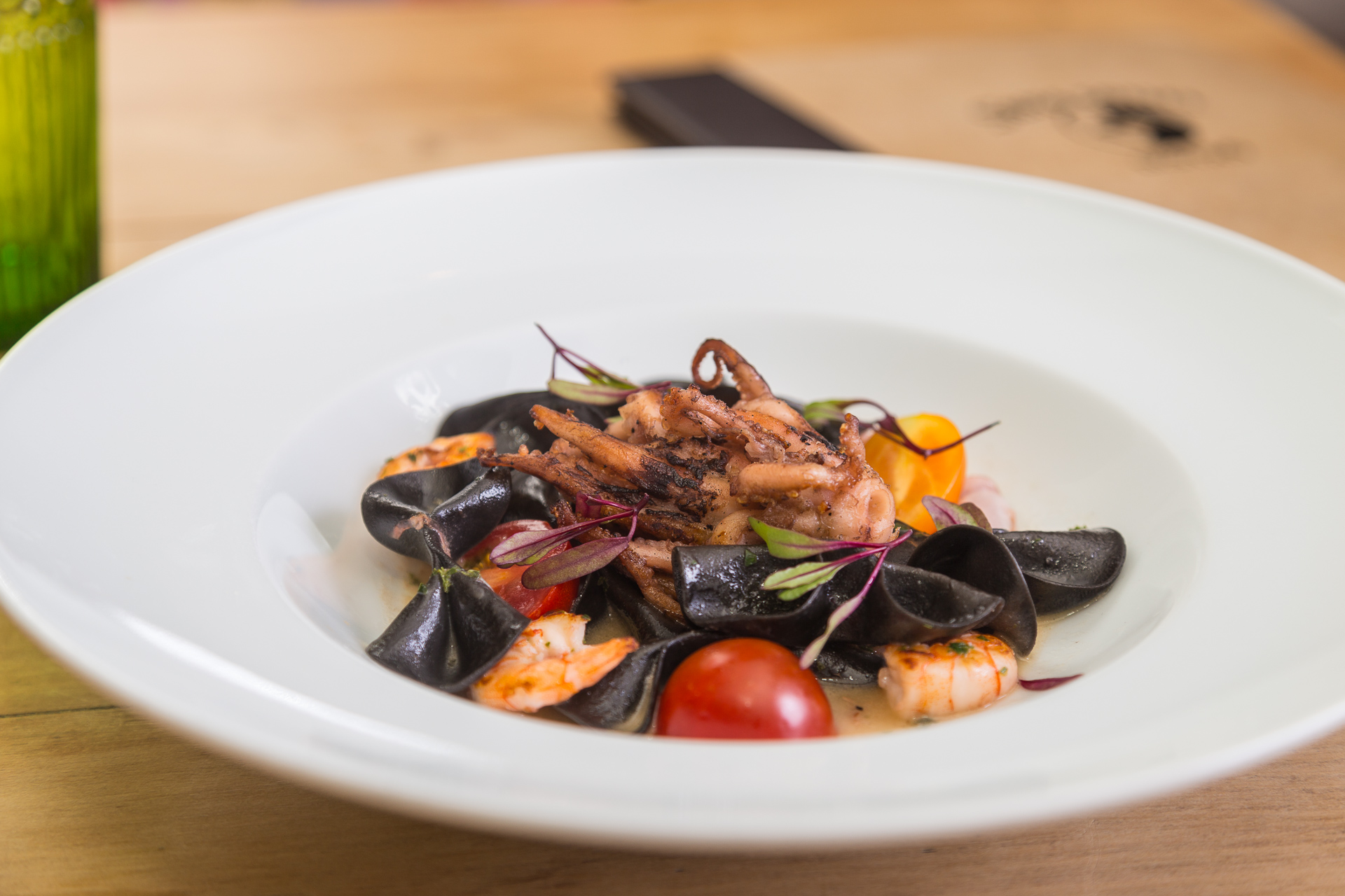 Farfalle negro com camarões, polvo grelhado e tomates